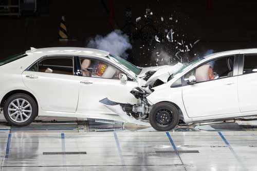 Two test cars undergoing a head-on collision in a controlled environment. 