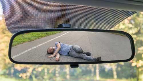A man lying on the ground after being injured in a hit and run. 