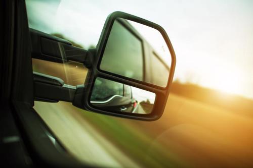 A close up shot of a tractor-trailers rear-view mirror showing its blindspot.